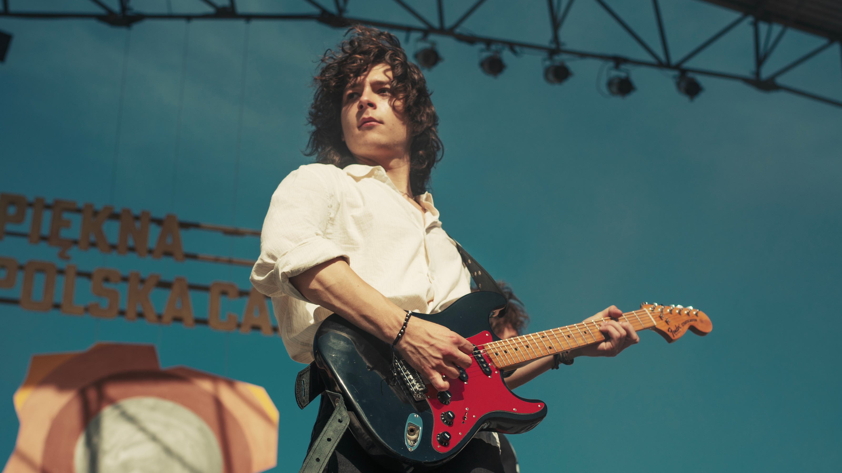 Mikołaj Bukrewicz as Jan Borysewicz playing guitar onstage in Less of a Stranger